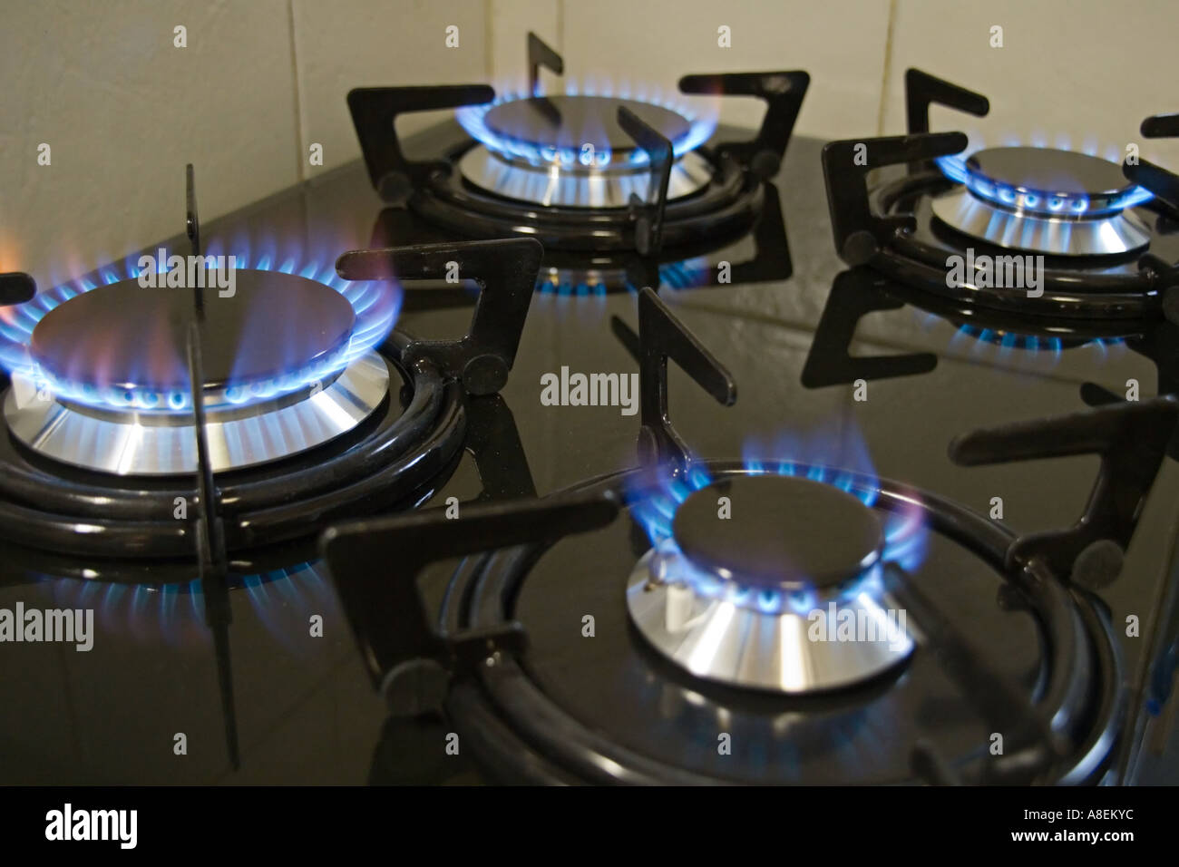 Stock photo of a black four burner gas stove with burners light