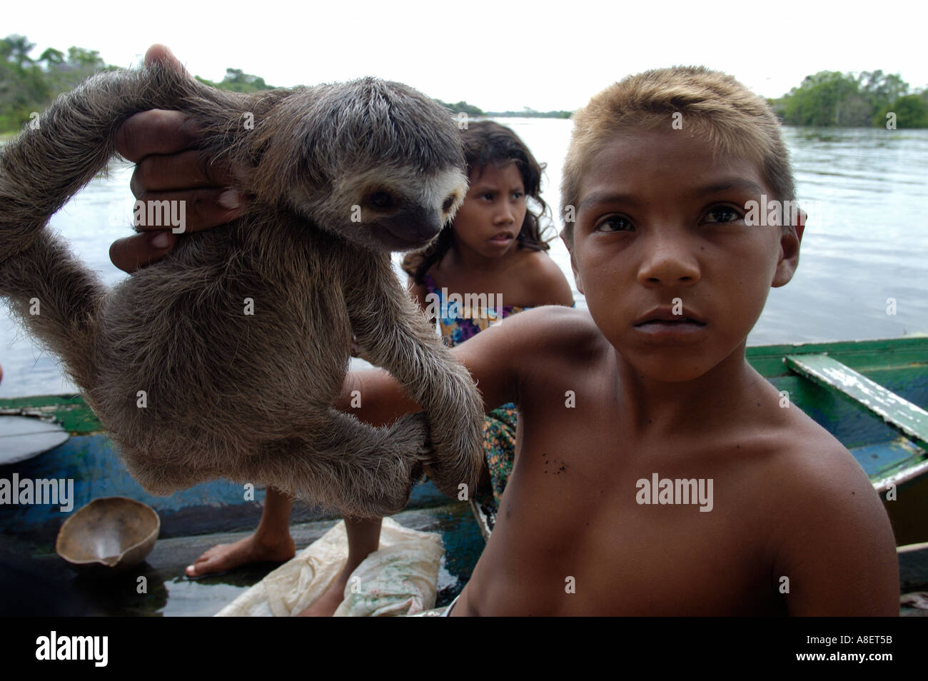 boy selling animals to tourist on amazon river in brazil on a ...