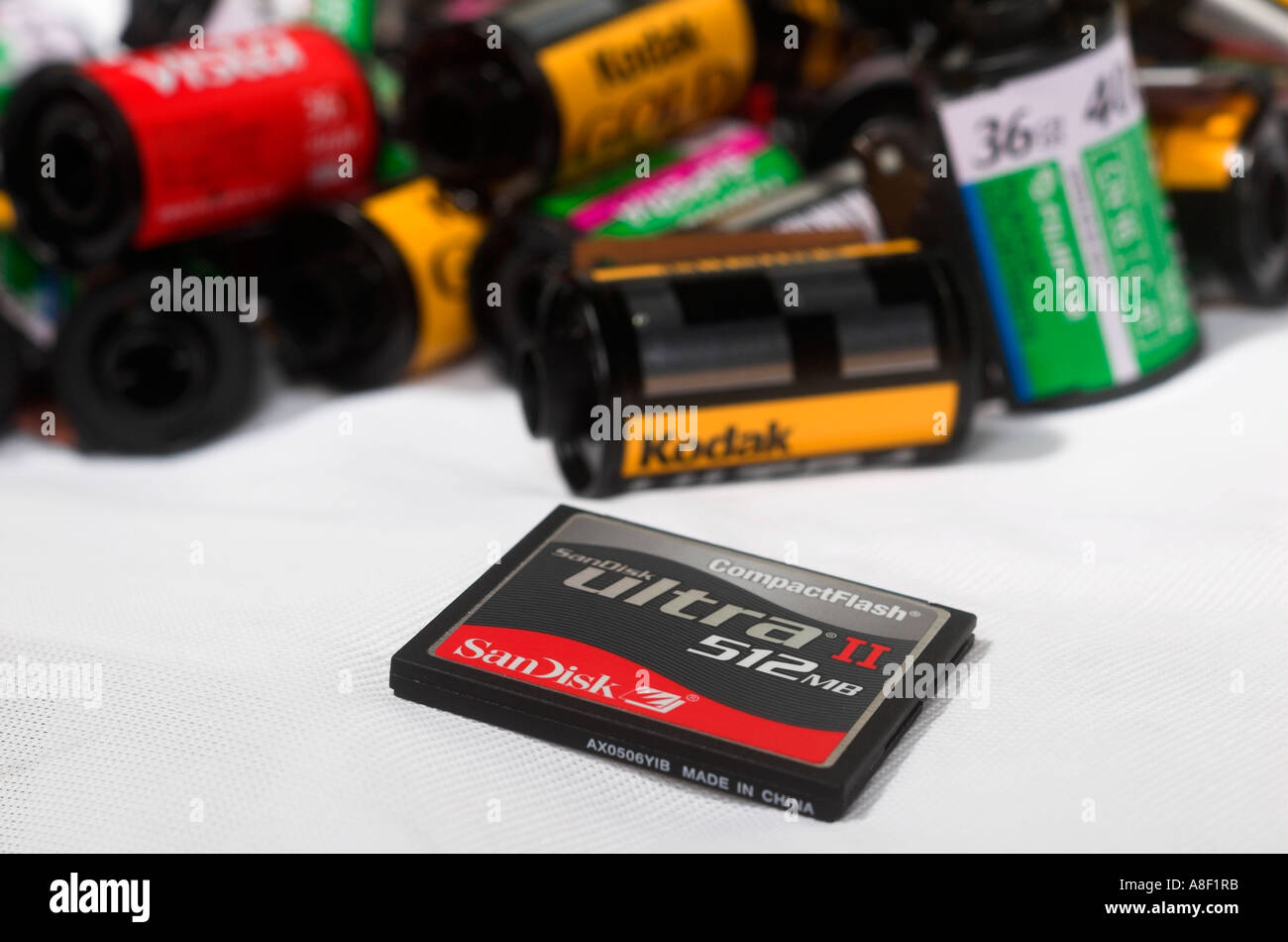 A 512mb scandisk compact flash card is seen lying in front of 35mm film