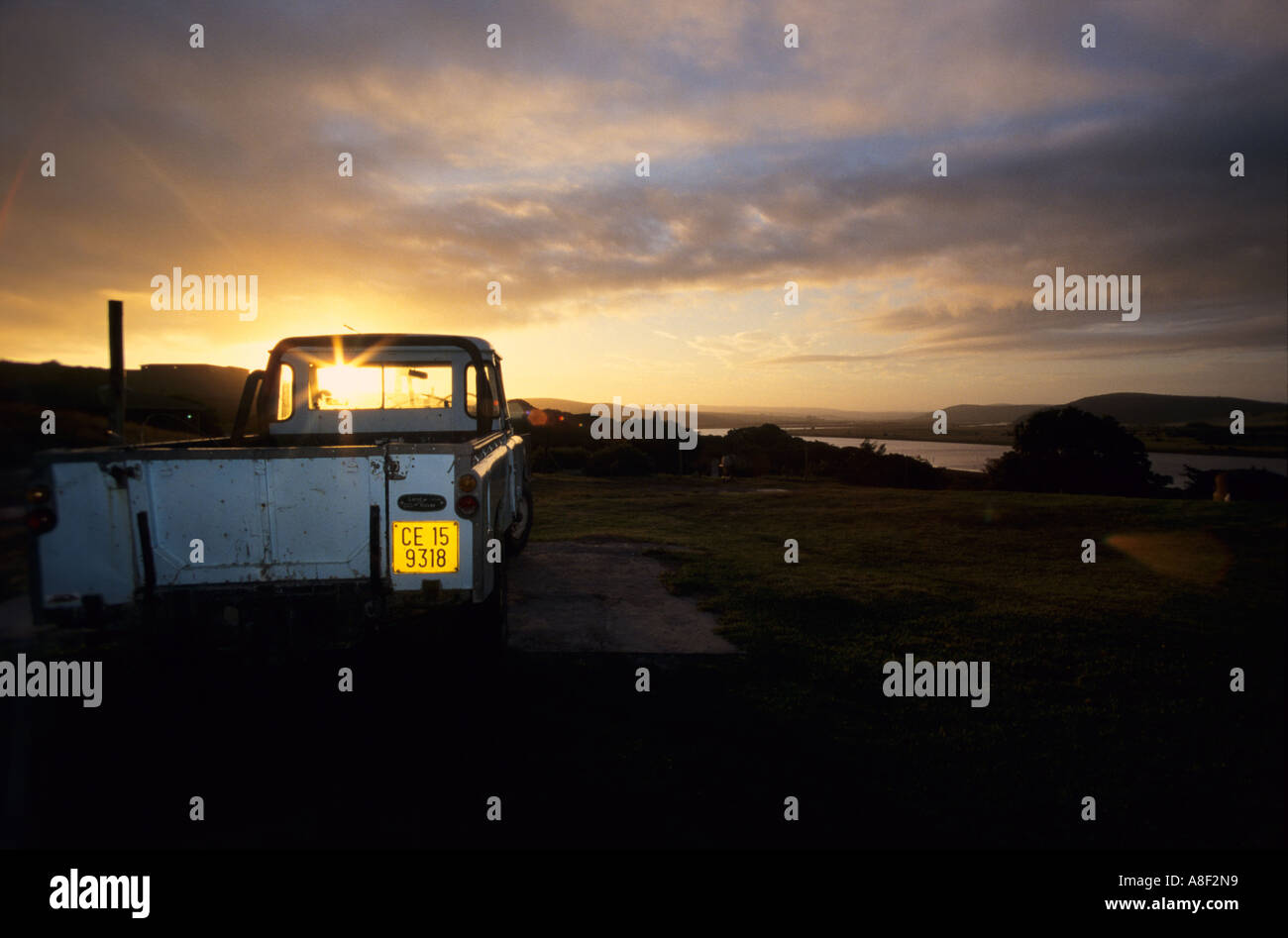 An original Land Drover defender stands in front of a stunning sunset. Stock Photo