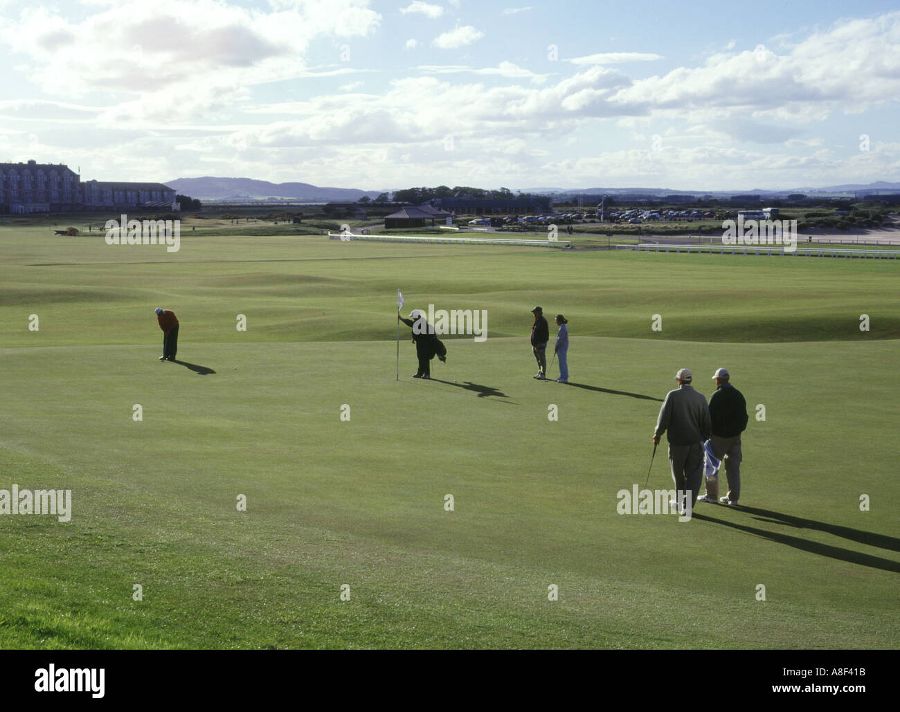 dh Golf ST ANDREWS FIFE Golfers on 18th green putting for hole links group scotland course uk Stock Photo