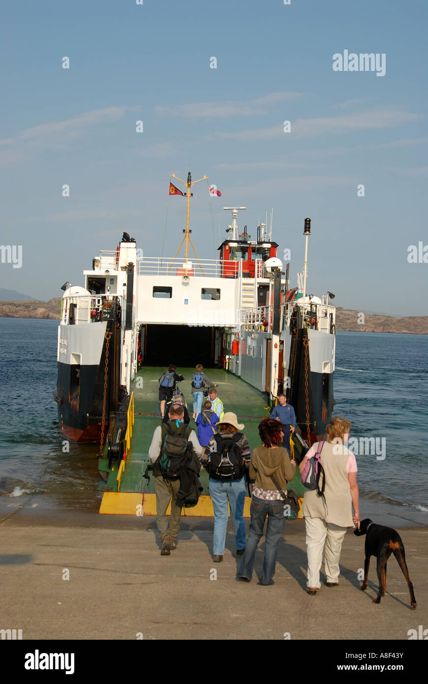 Foot passengers embarking onto a small carferry, a ten minute sea crossing to Fionnphort on the Isle of Mull from the Iona Stock Photo