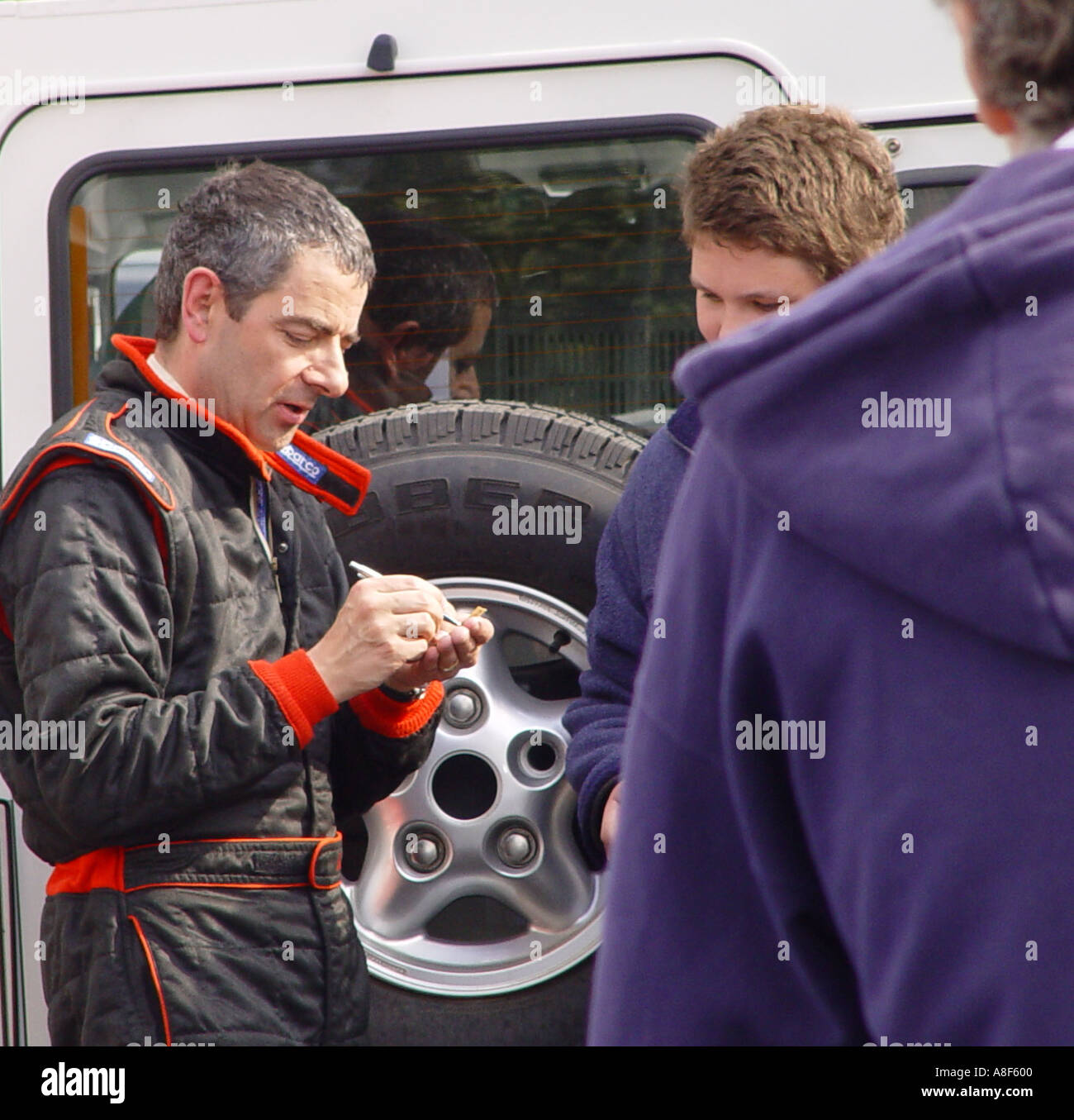 Rowan Atkinson signing autographs at a motor racing circuit England GB UK 2003 Stock Photo