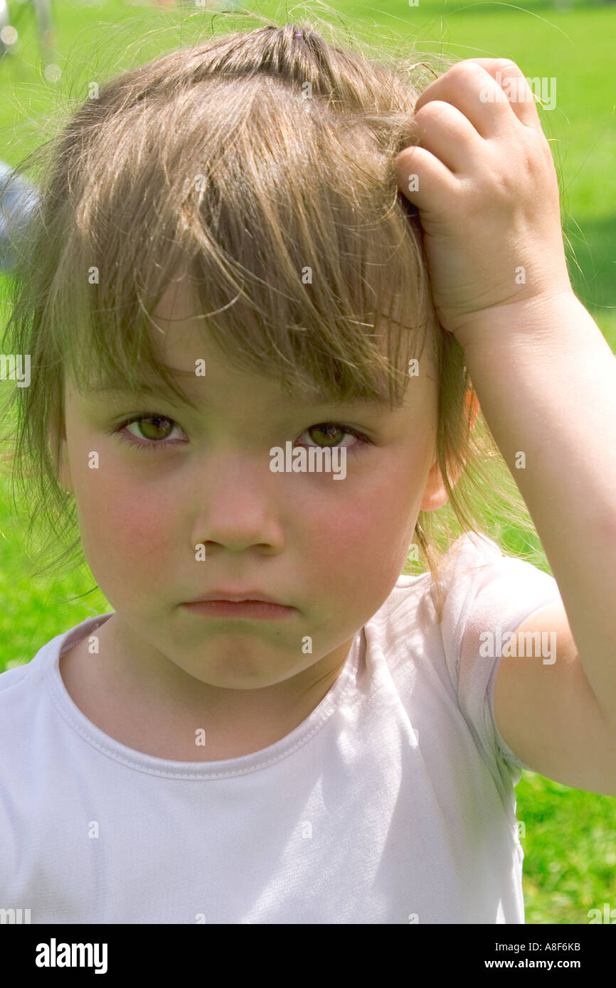 Sad girl holding a hand on her head Stock Photo - Alamy