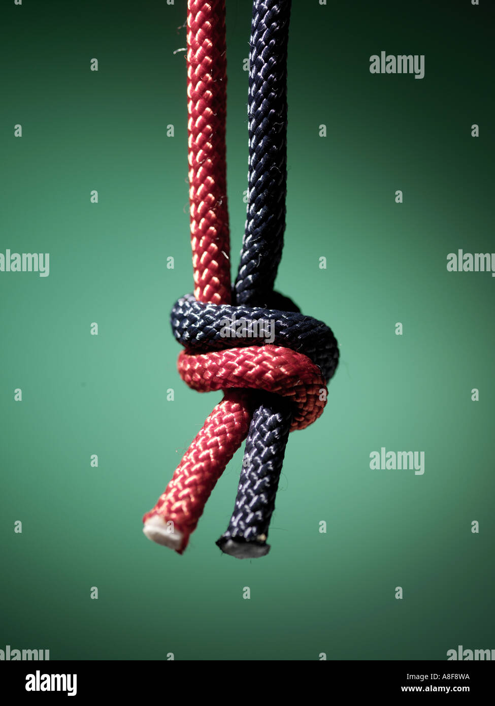 rope, twice, tied knot, blue, red, tough, close up, green background, fabric, tighten, strings Stock Photo