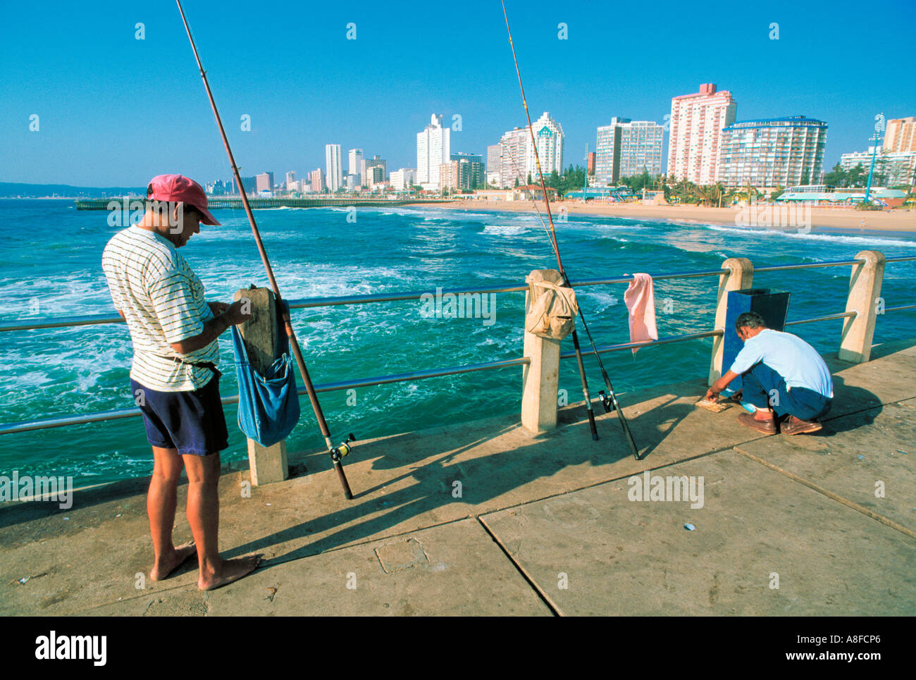 https://c8.alamy.com/comp/A8FCP6/fisherman-on-pier-with-fishing-rod-durban-south-africa-A8FCP6.jpg