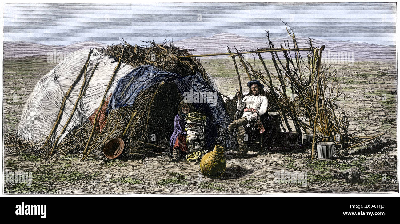 Apache family in front of their wickiup 1880s. Hand-colored woodcut Stock Photo