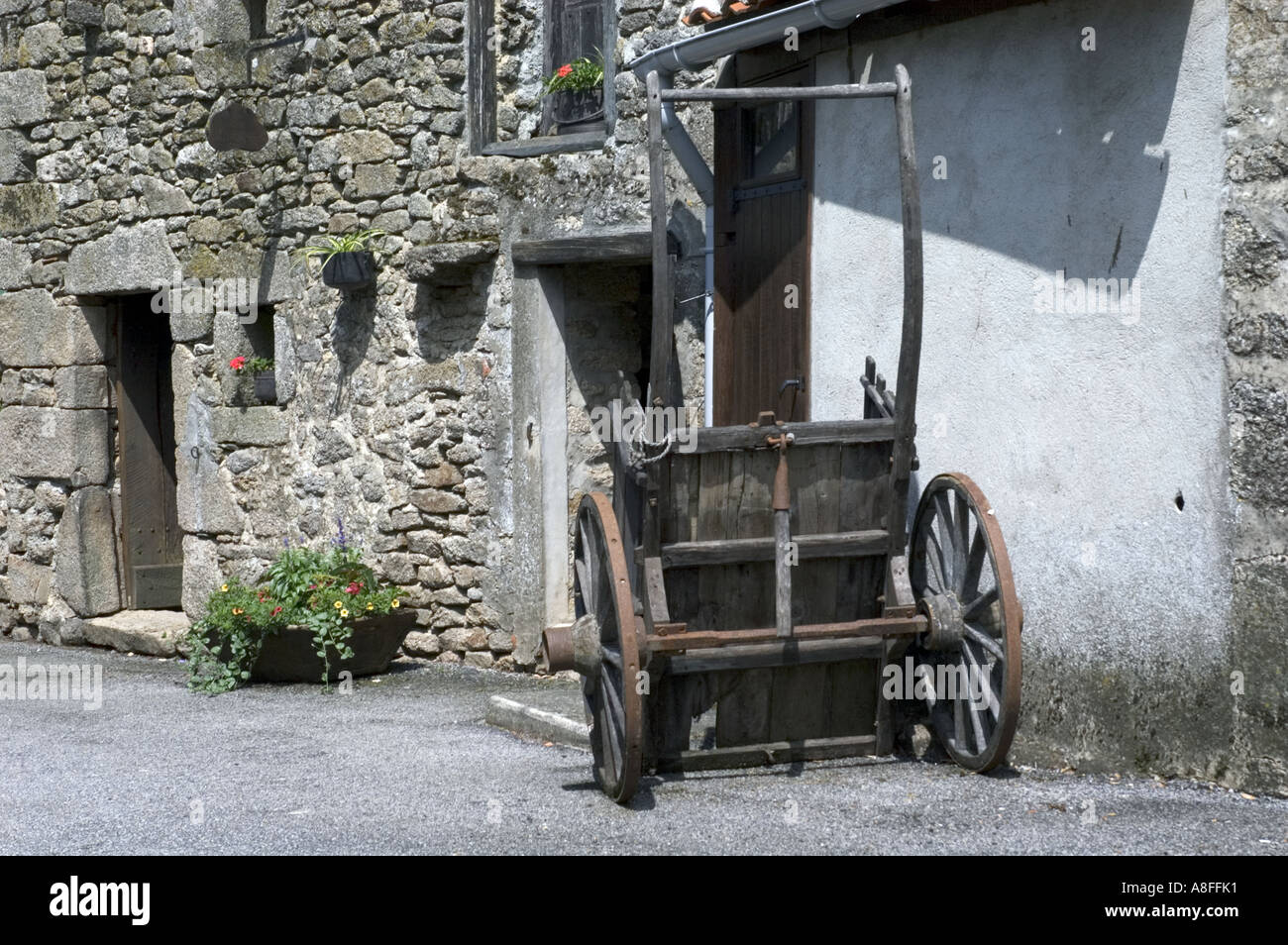 old cart leaning against a wall in the French village of Montrol Senard in the Limousin region Stock Photo