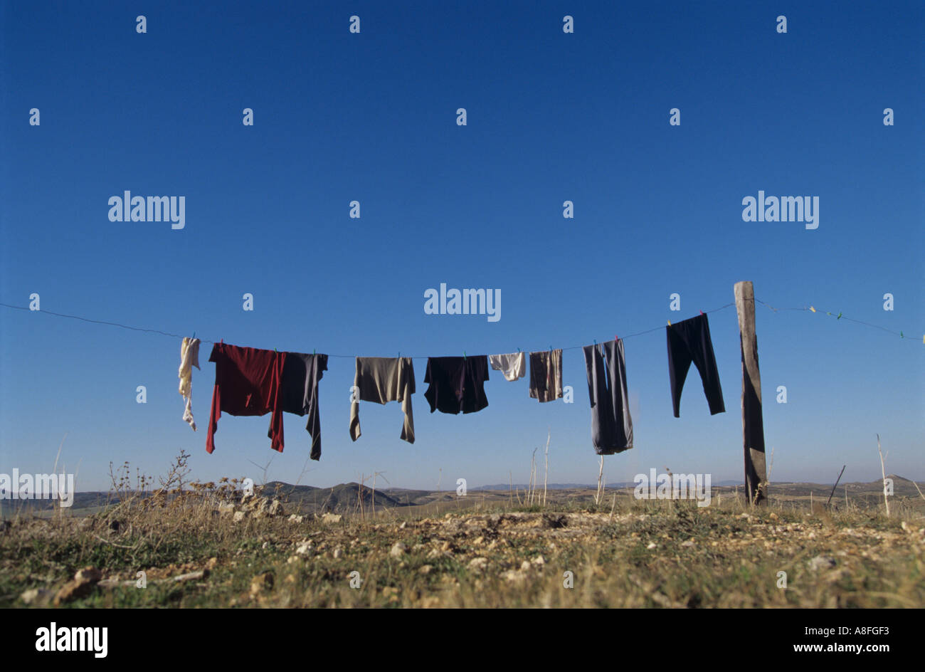clothesline against blue sky in arid landscape Stock Photo