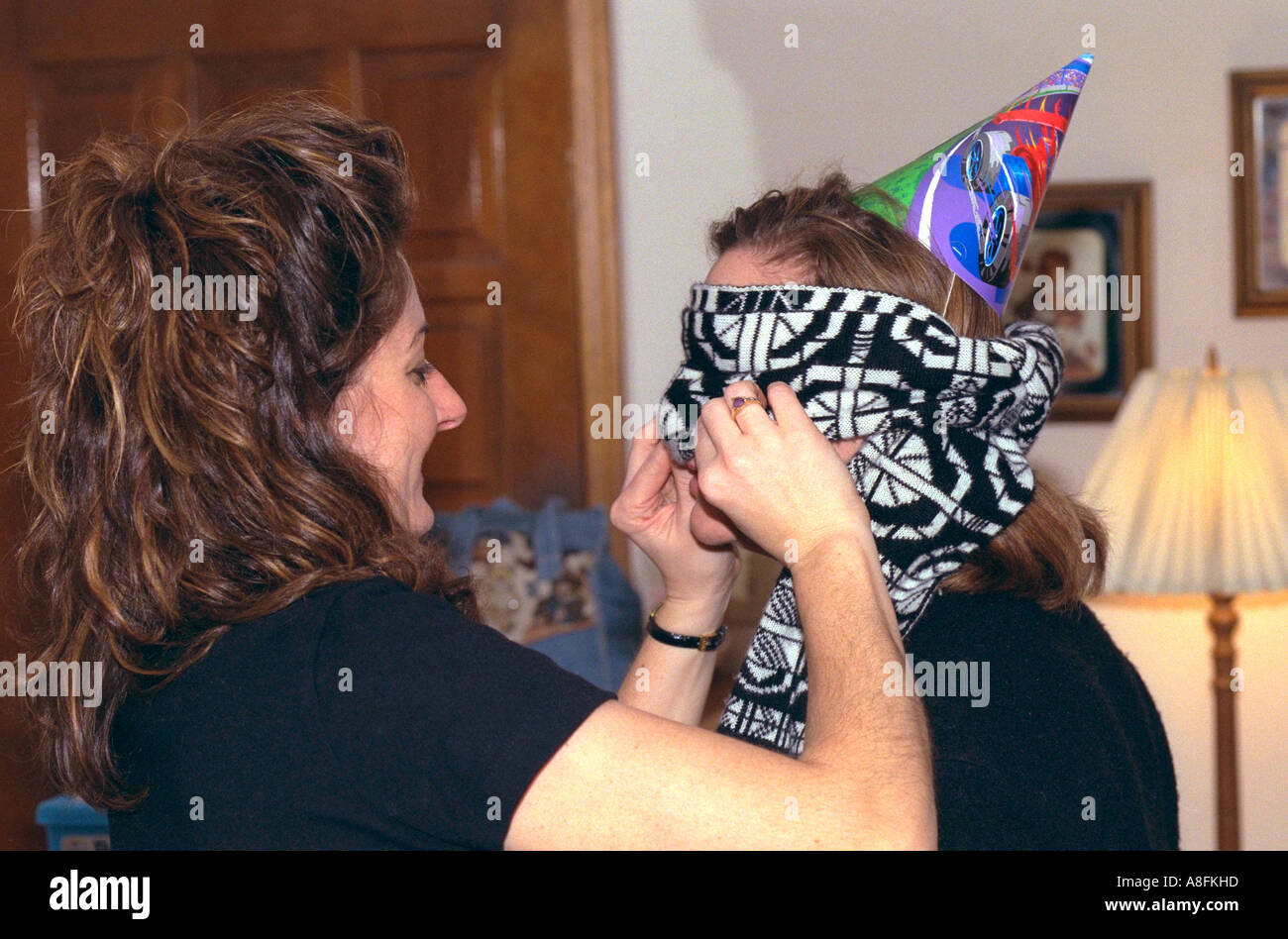 Mom checking mask for blindman's bluff birthday party game age 32. Brooklyn Park Minnesota USA Stock Photo