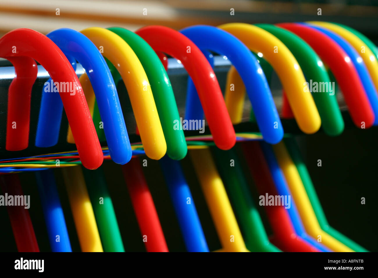 Coloured clothes hangers on a chrome rail Stock Photo - Alamy