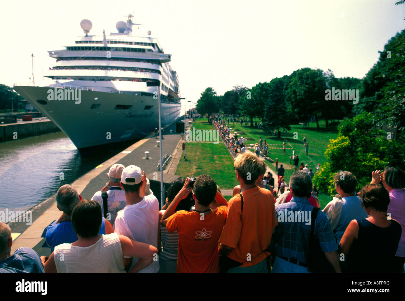 Visitors welcome the passenger ship pass through a Lock the North and Baltic sea canal in Brunnsbuettel Germany Stock Photo