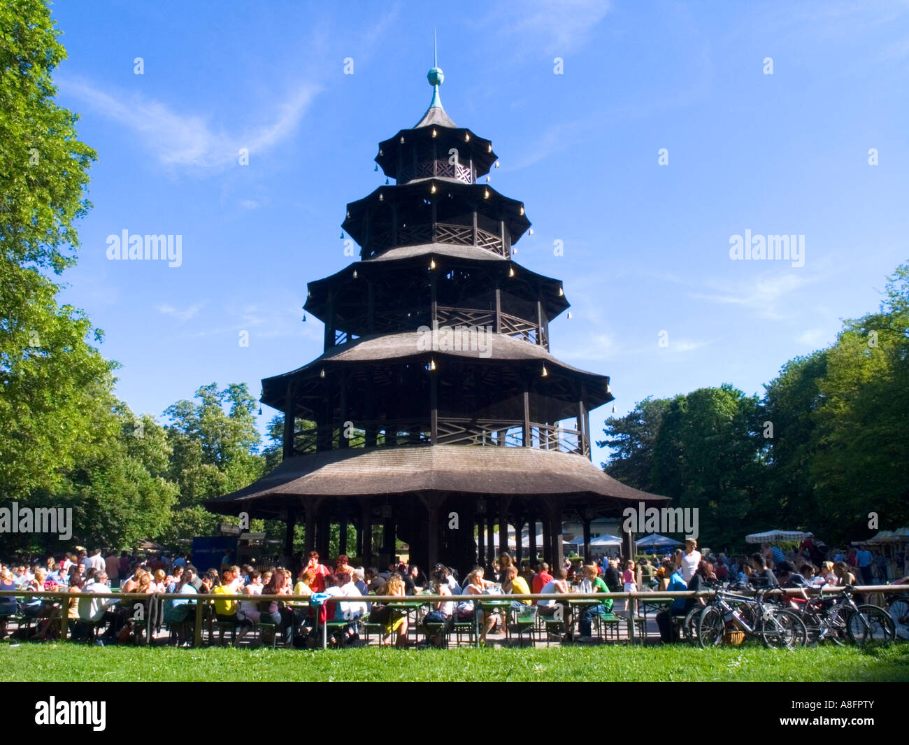 People enjoy beer in beer garden chinese tower English garden munich bavaria germany Stock Photo