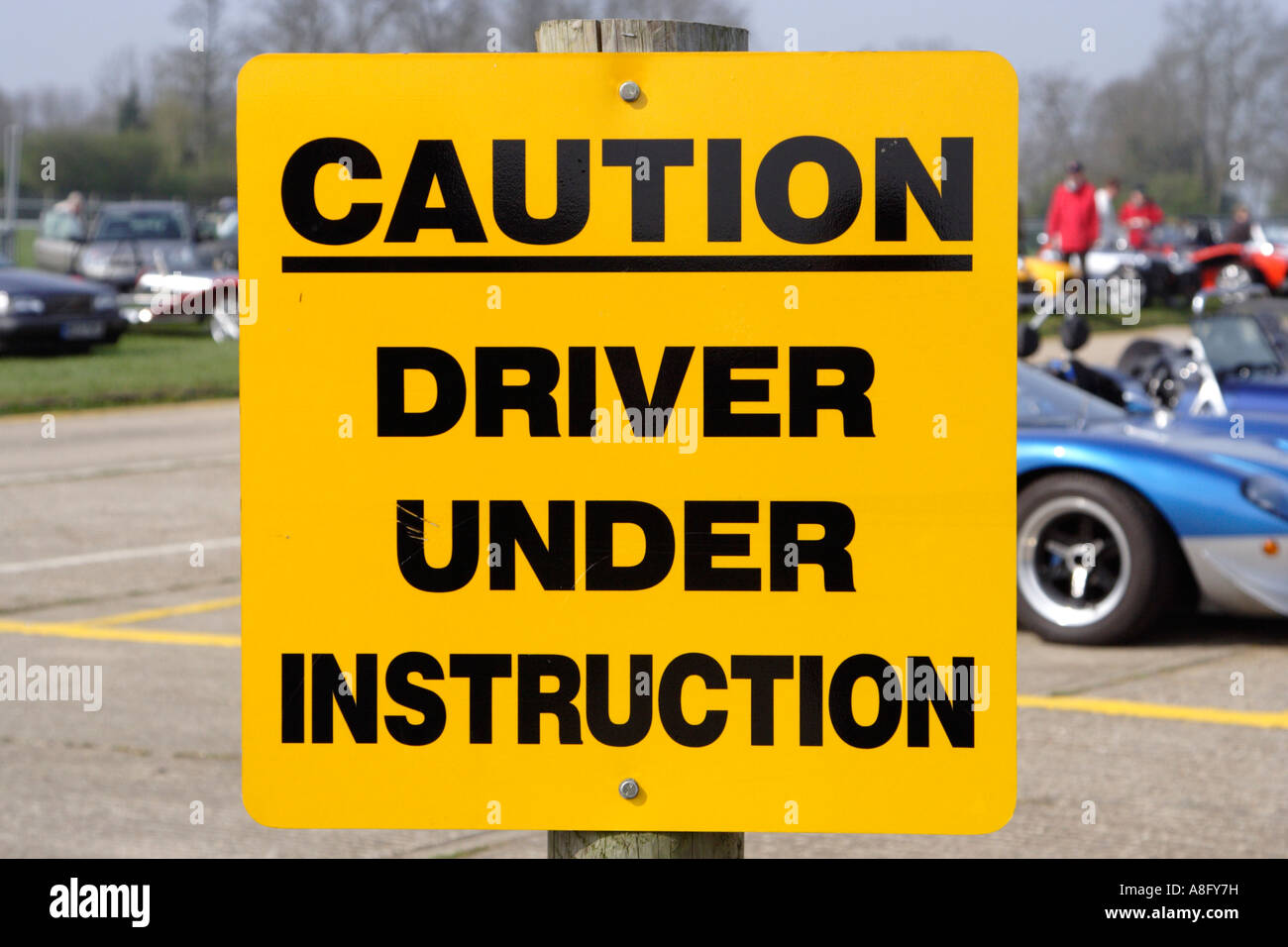 bright yellow sign saying caution driver under instruction Stock Photo