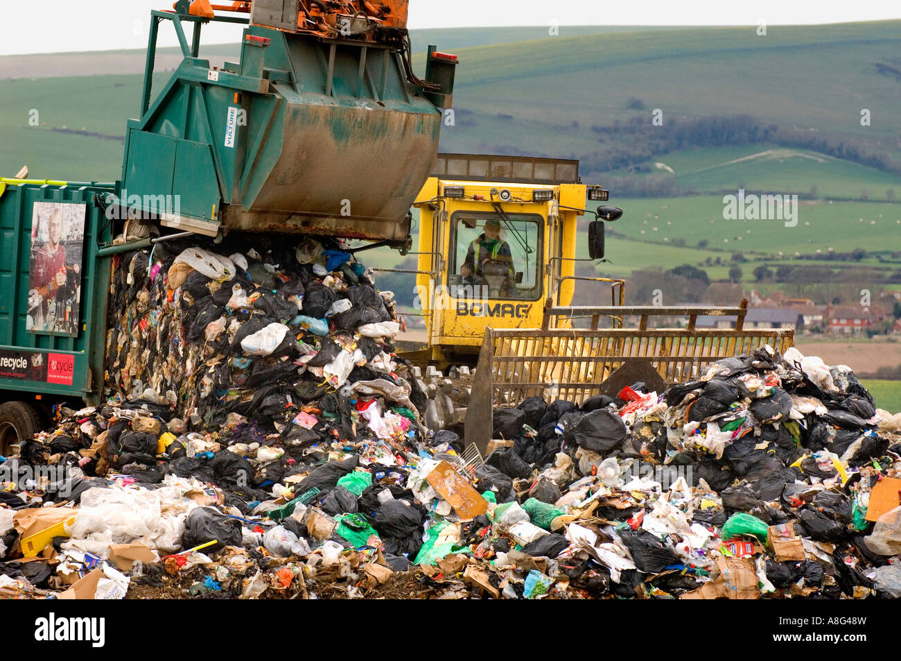 A busy landfill site in action with dustcarts refuse trucks and bulldozers. Beddingham, South East UK. Stock Photo