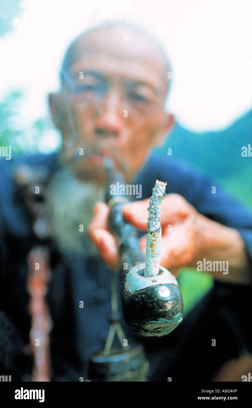 old man smoking with smoking pipe, Yangshuo, China Stock Photo