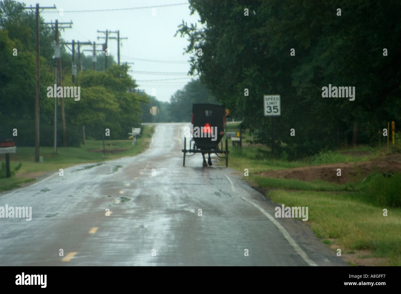 Soft Focus View of Amish Carriage through Vehicle Windshield on Rain Slicked Road Stock Photo