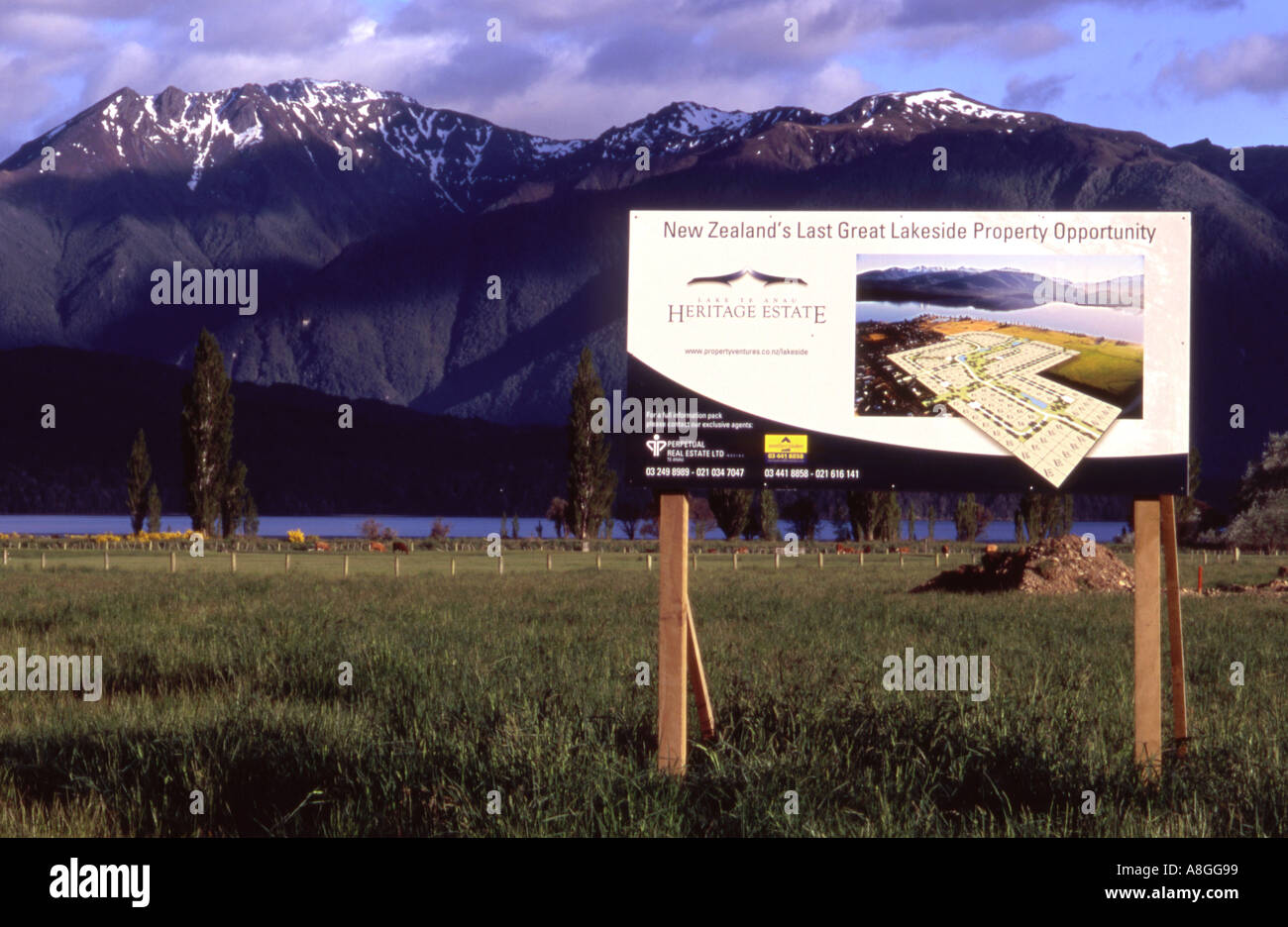 Real Estate sign in a proposed development section Te Anau Fiordland with mountains of National Park background New Zealand Stock Photo