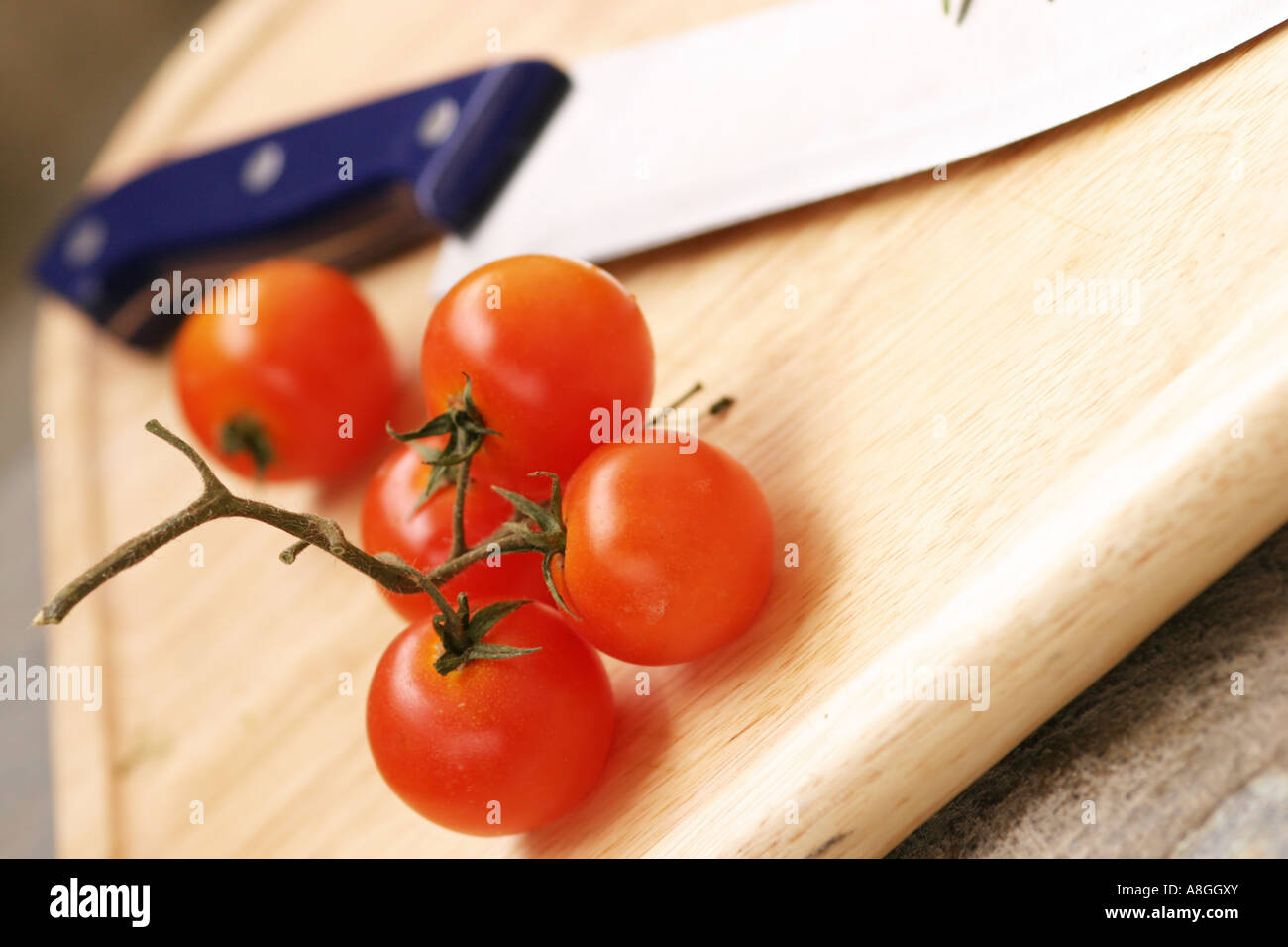 Cherry tomatoes and knife Stock Photo - Alamy