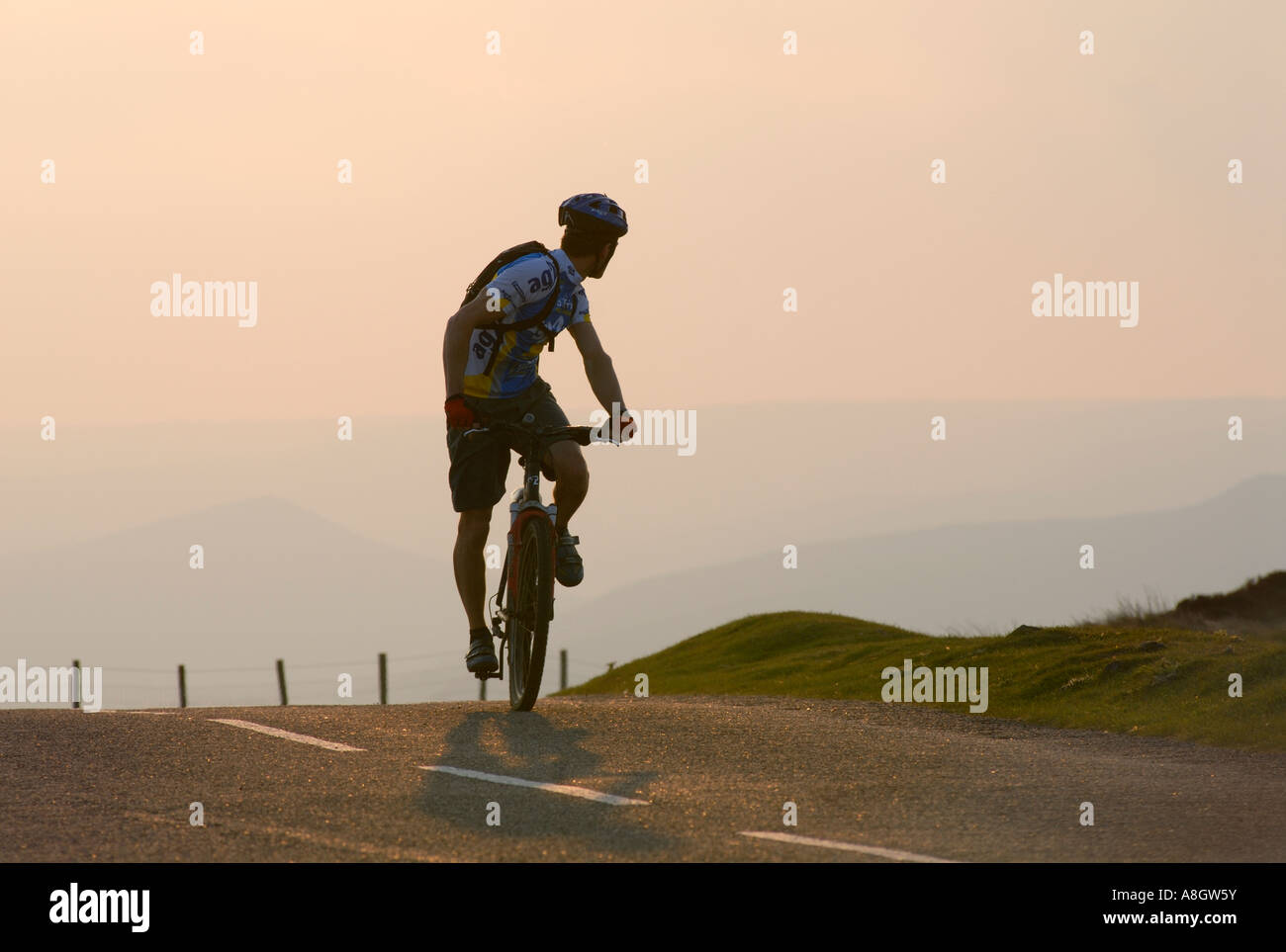 Cyclist looking behind himself climbing up to  the top of a steep hill at Stanage  in Derbyshire 'Great Britain' Stock Photo