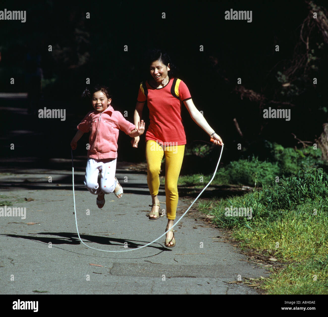 6623 Mother and 7 year old daughter jump rope in Golden Gate Park San Francisco California USA Stock Photo