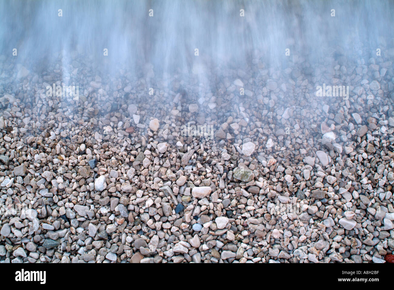 Ocean Waves Lapping the Pebble Covered Sea Shore Stock Photo