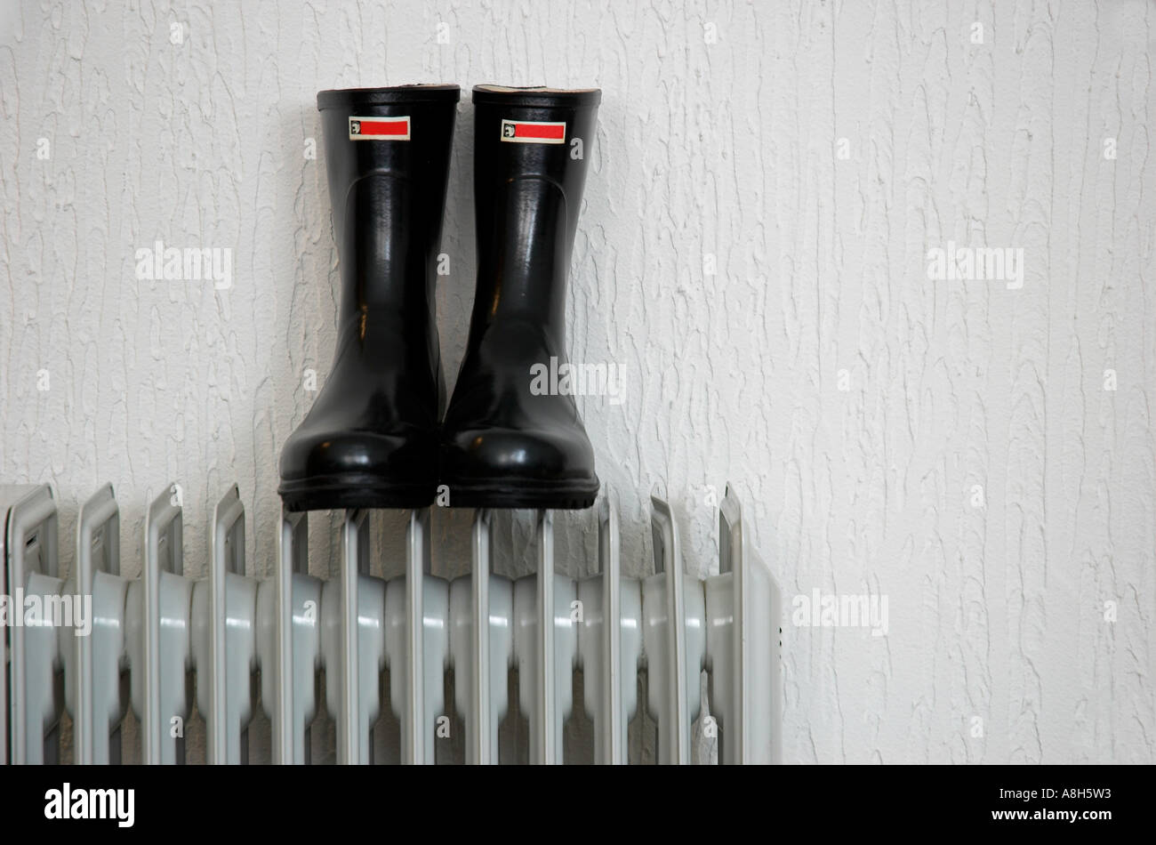 Rubber boots on radiator Stock Photo - Alamy