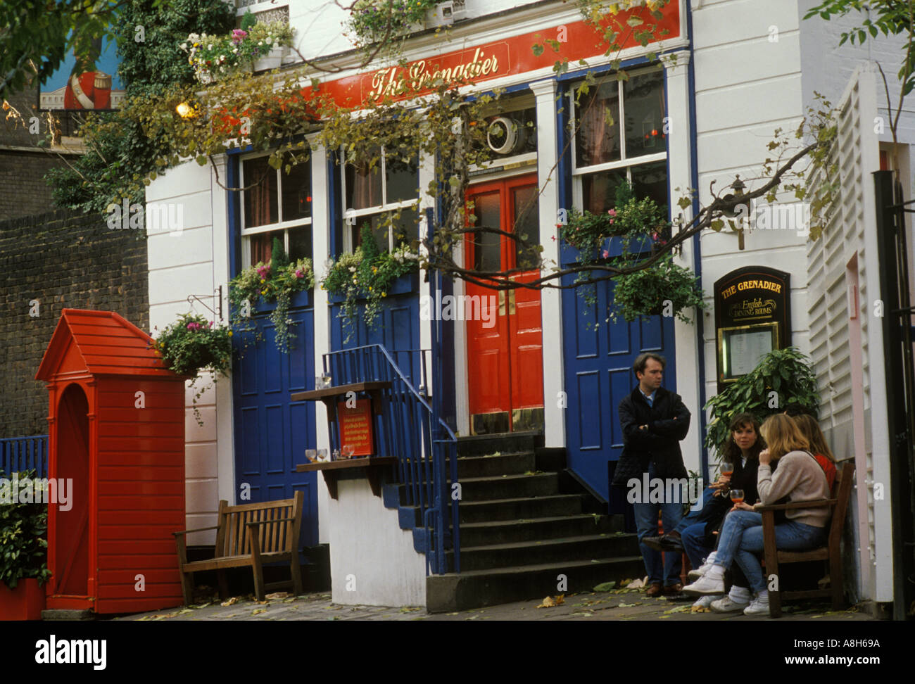 Grenadier pub, group people outside of the front of building. Near Hyde Park, Wilton Row, Wilton Mews, Belgravia, London England. 1990s Stock Photo