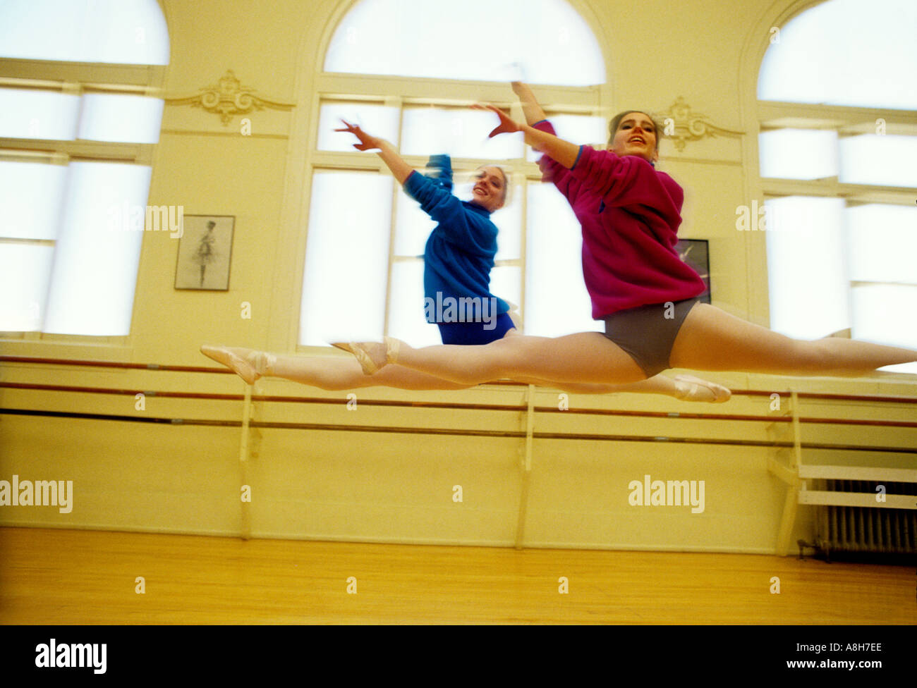two dancers execute a grand jete in a studio Stock Photo