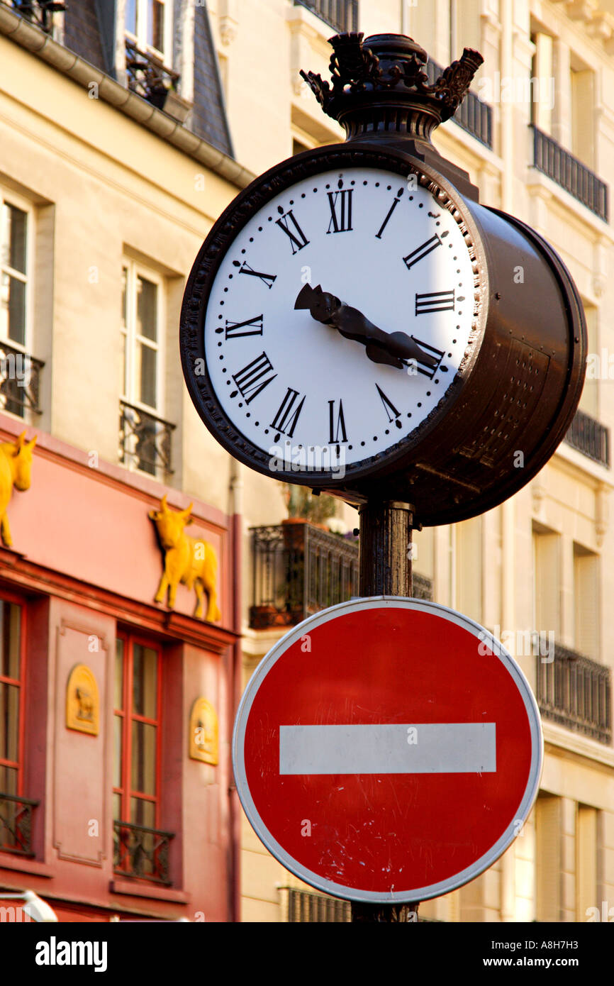 Parisian street clock and traffic sign - Paris, France Stock Photo