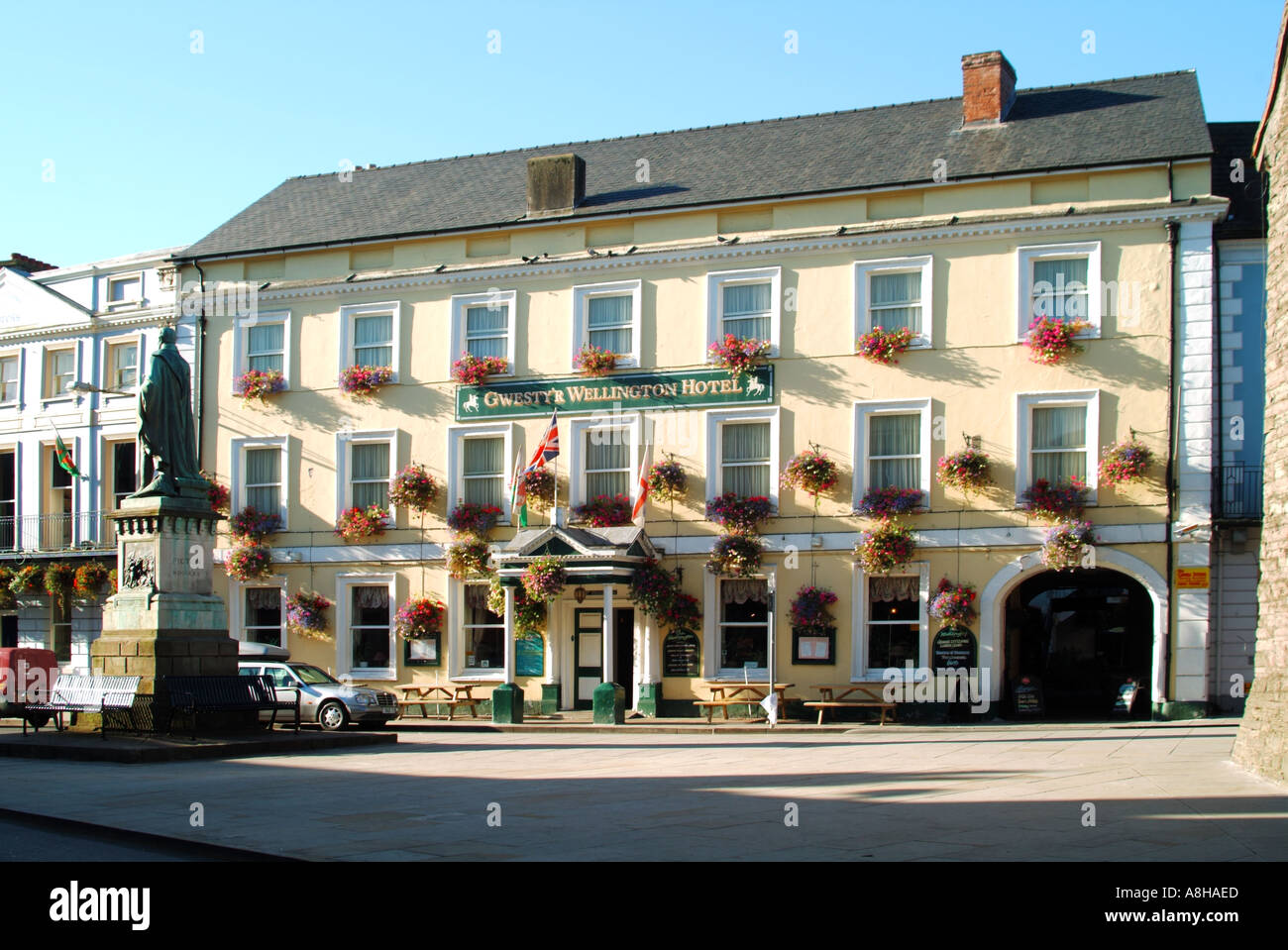 Brecon town centre Wellington hotel frontage colourful display of summer flowers & statue of Arthur Wellesley 1st Duke of Wellington Powys Wales UK Stock Photo