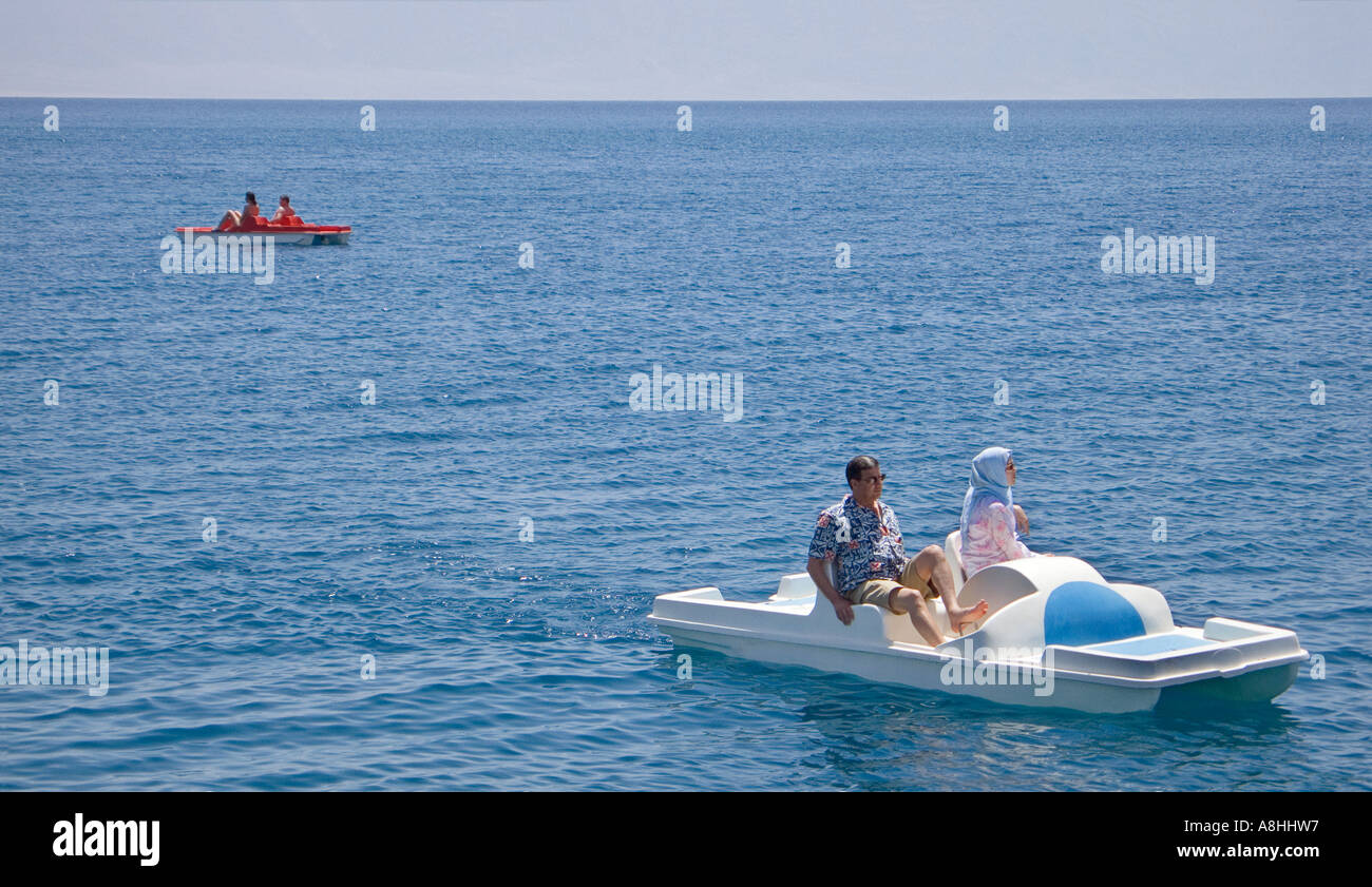 Egyptian man and woman on a pedalo and another pedalo in the distance at Nuweiba on the Red Sea Coast Sinai Egypt Stock Photo
