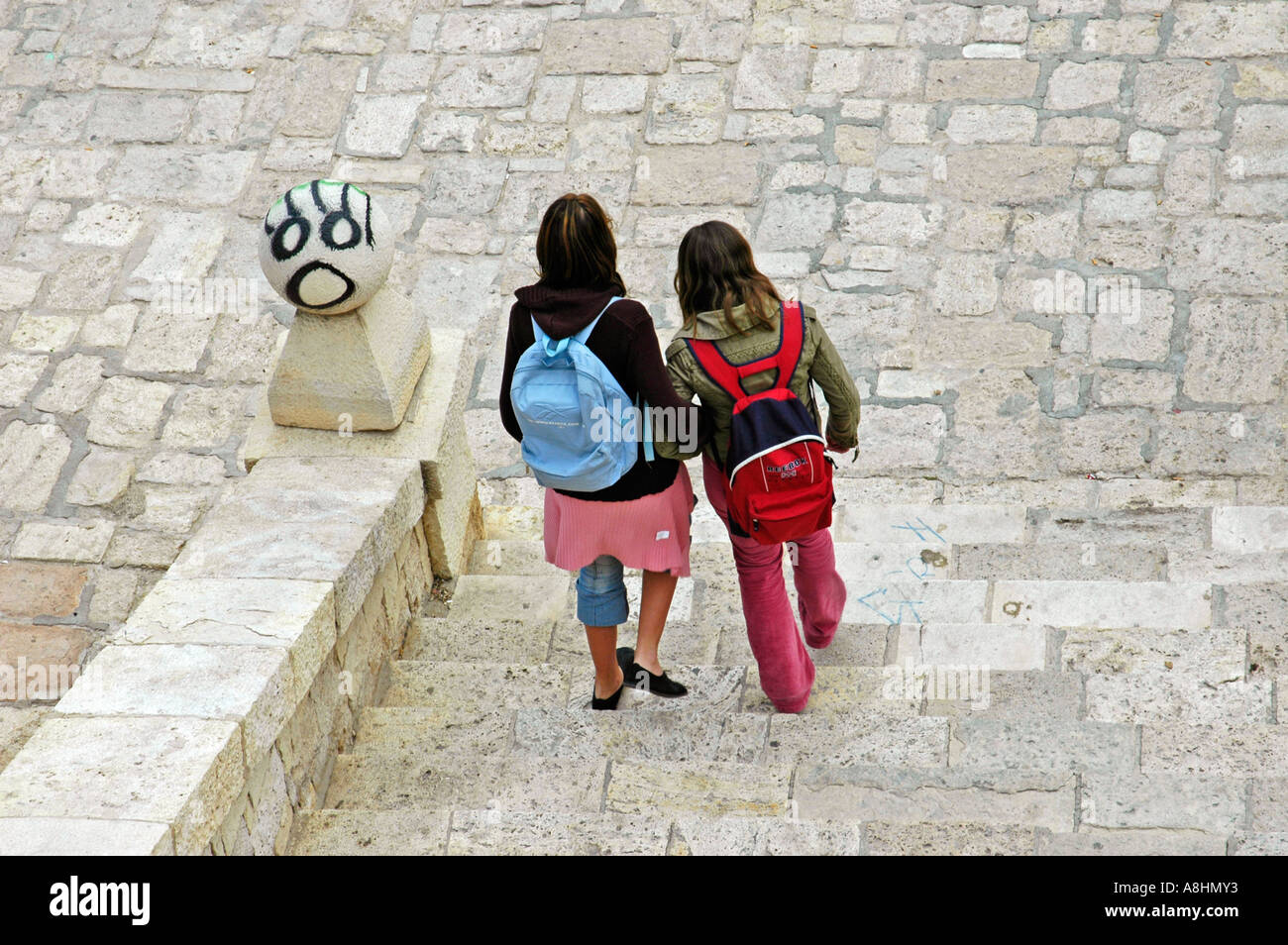 School kids with rucksack going down stairs, two friends, Graffiti, Alicante, Spain Stock Photo