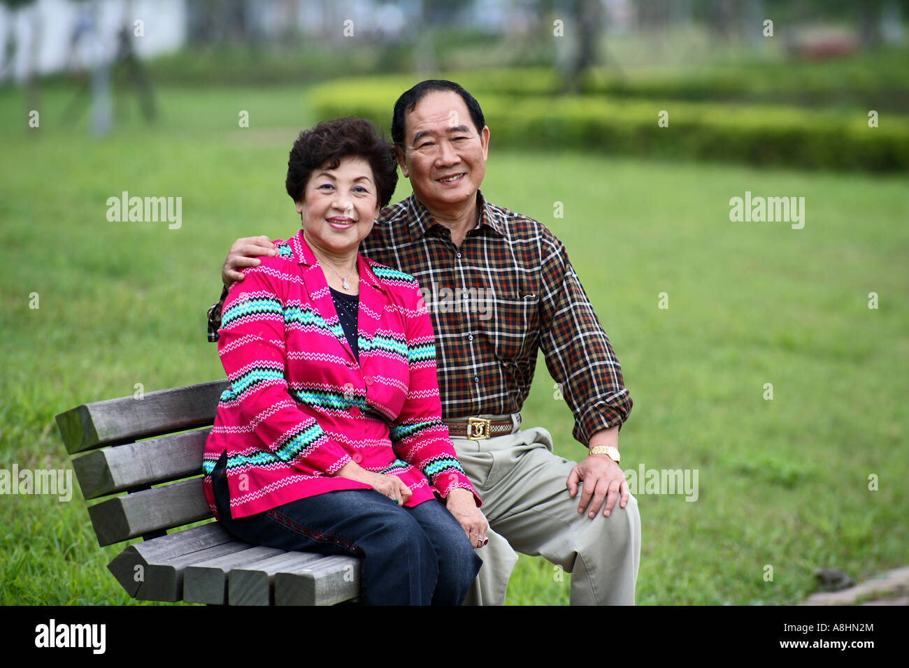 Portrait of senior couple sitting on bench Stock Photo - Alamy