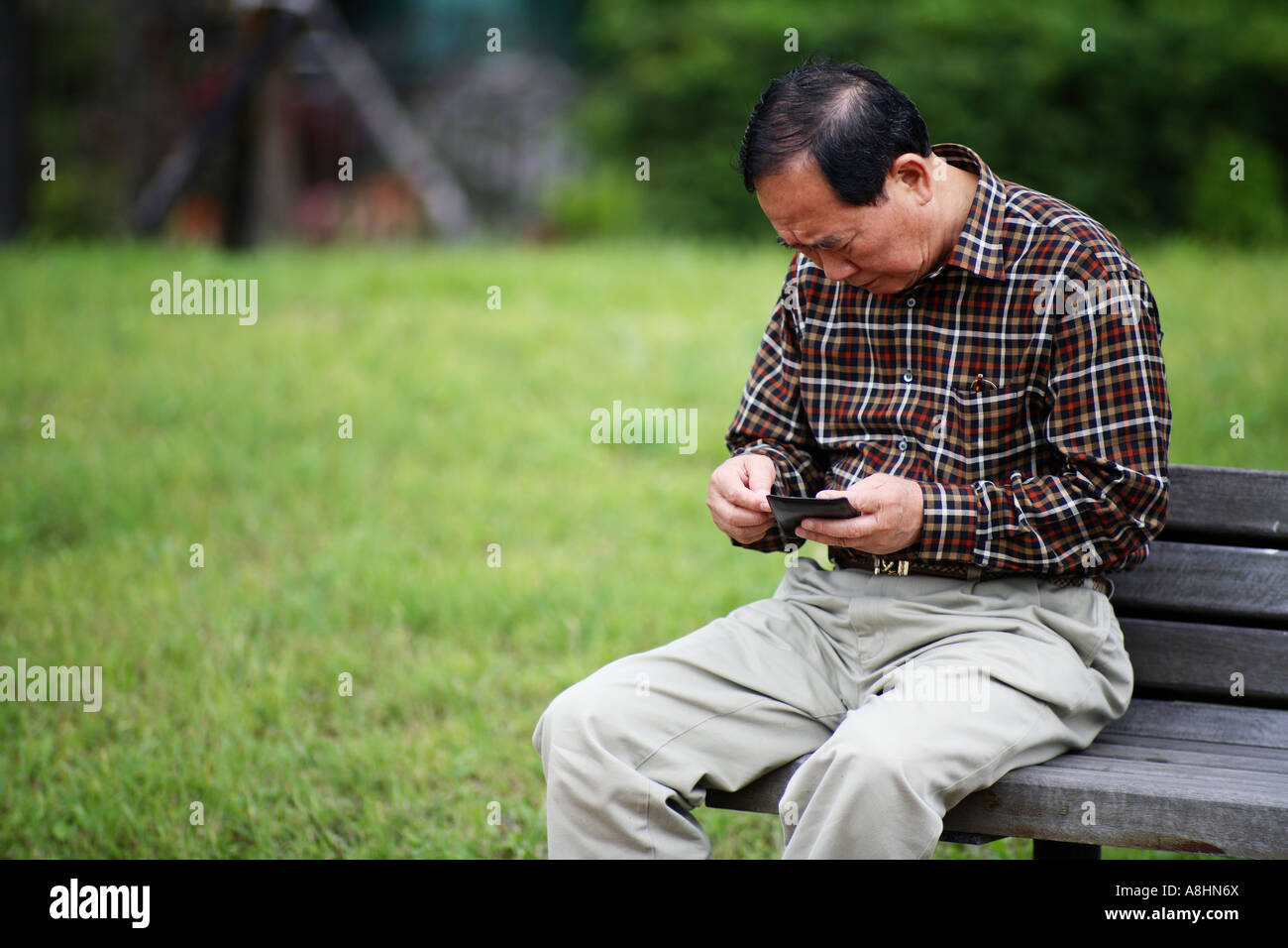 A man sitting in a garden on bench Stock Photo - Alamy