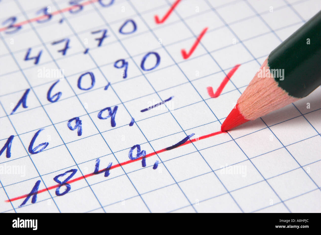 Cutting costs, money amount being deleted from a list using a red pencil Stock Photo