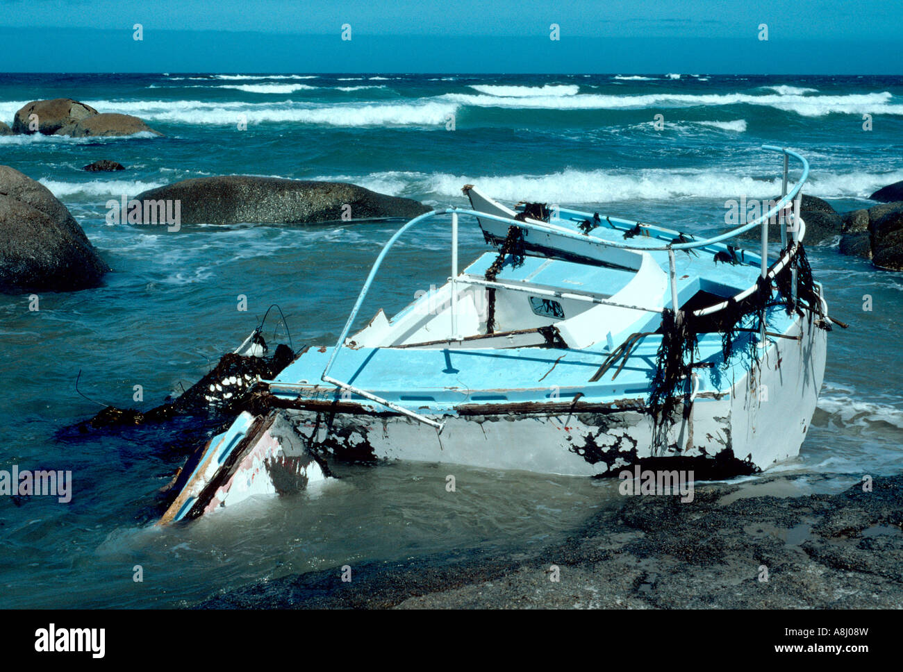 Yacht wrecked on coastal rocks in Australia Stock Photo