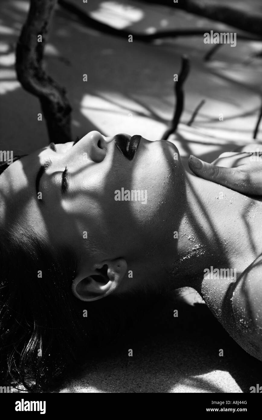 Pretty Filipino nude young woman on beach in tree shadows in Maui