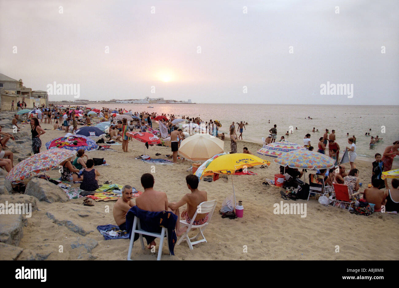 People enjoy a summer evening at the Moretti Club des Pins beach