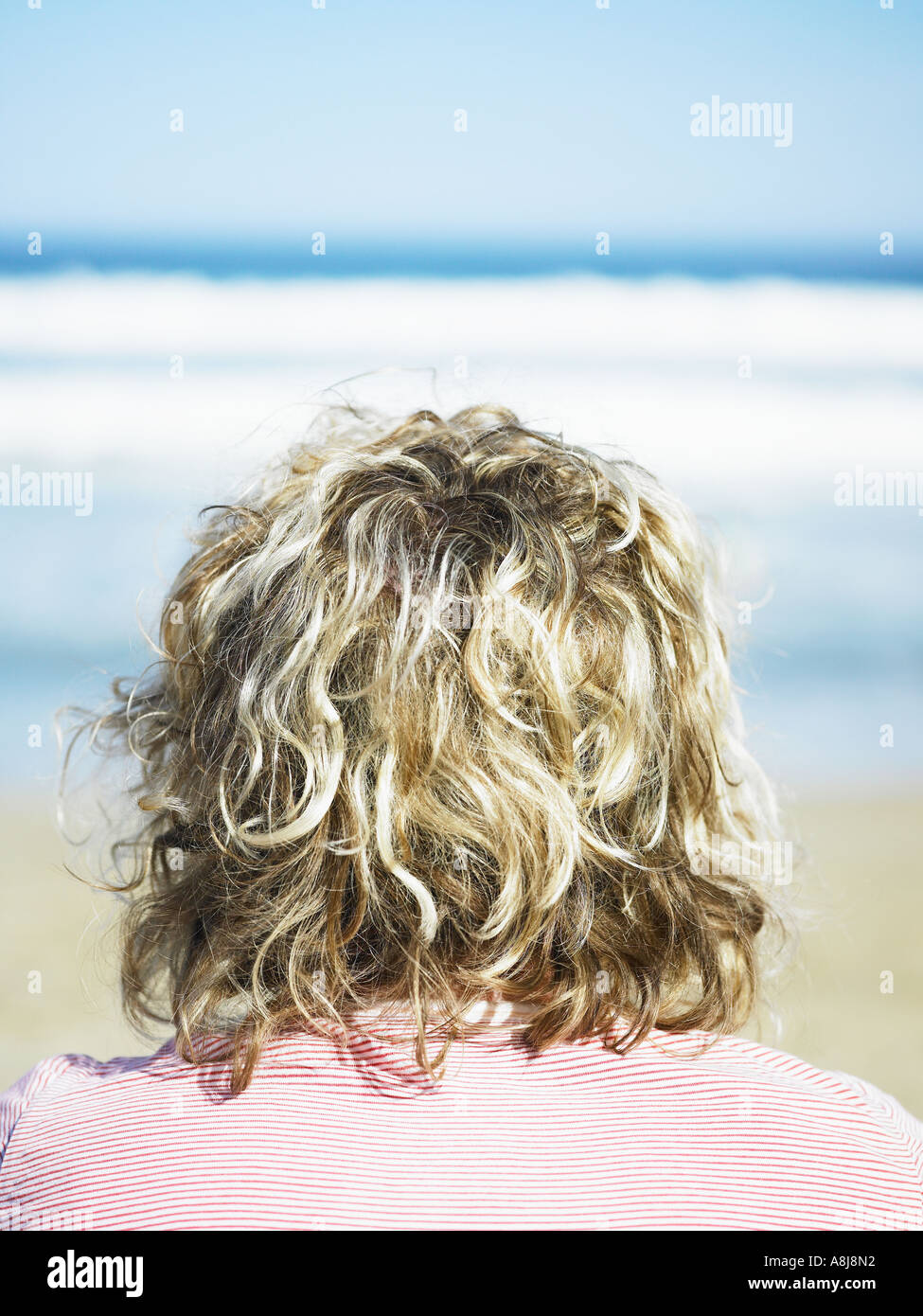 Beach Bum Girl With Bleached Curly Hair Looking Out To The Ocean