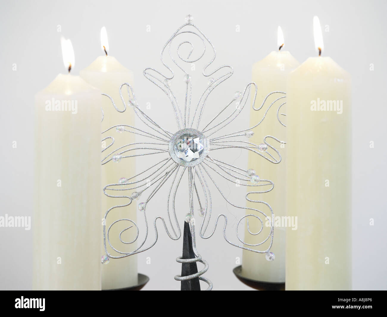 four candles on stand with xmas decoration in the middle Stock Photo