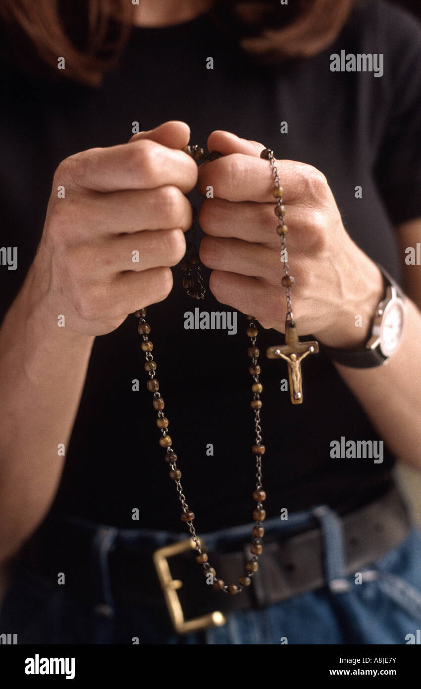 Woman praying using a rosary Stock Photo - Alamy