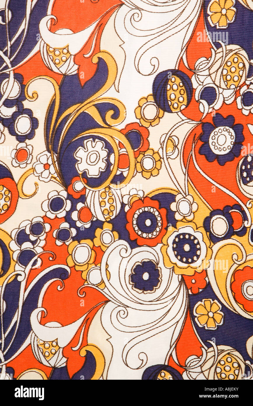Close up of vintage fabric with red blue and gold flowers and swirls ...