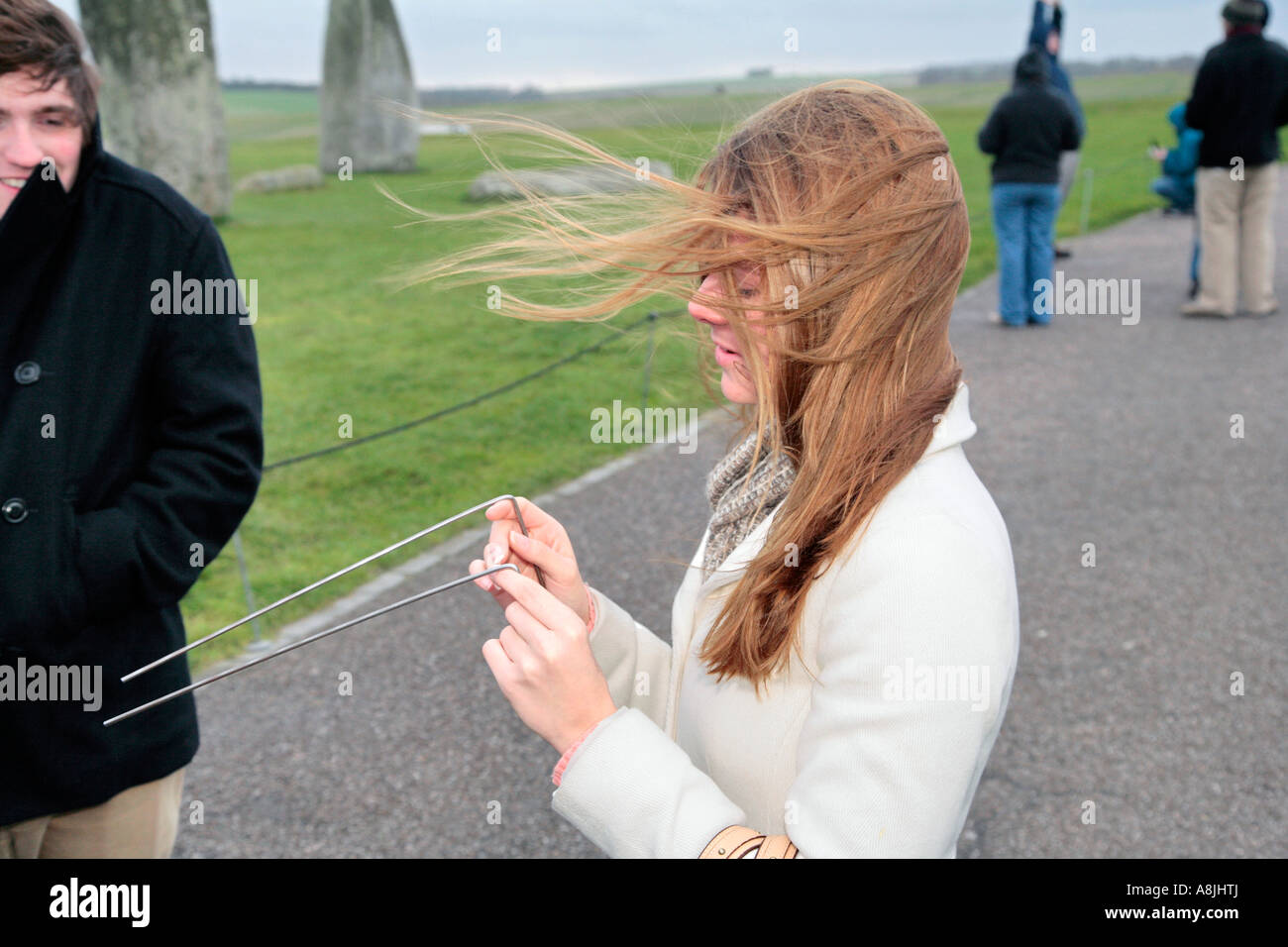 a red-headed woman with divining rods at stonhenge, wiltshire, england Stock Photo