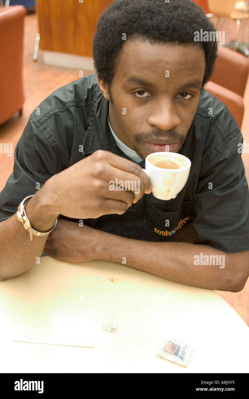 african male sitting down drinking coffee Stock Photo Alamy