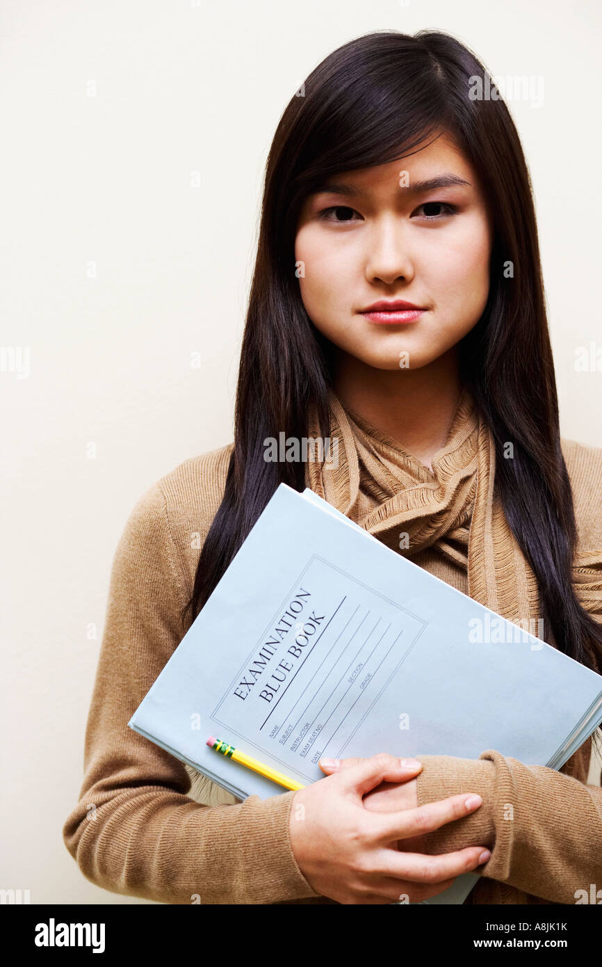 Portrait of a young woman holding a pencil and a book Stock Photo - Alamy