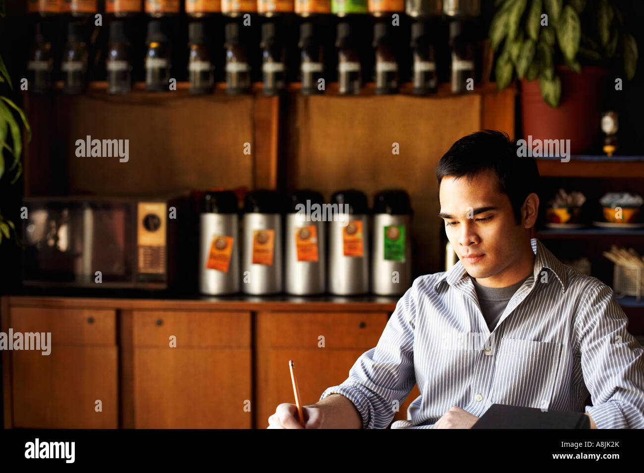 Young man writing with a pencil Stock Photo - Alamy