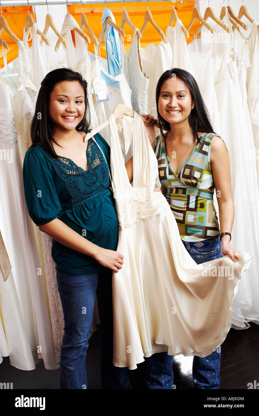 Portrait of two young women standing in a clothing store Stock Photo ...