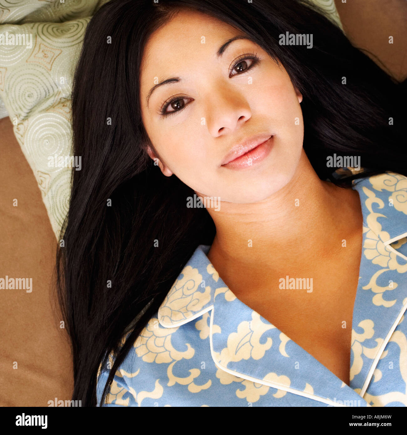 Portrait of a young woman lying on a couch Stock Photo - Alamy