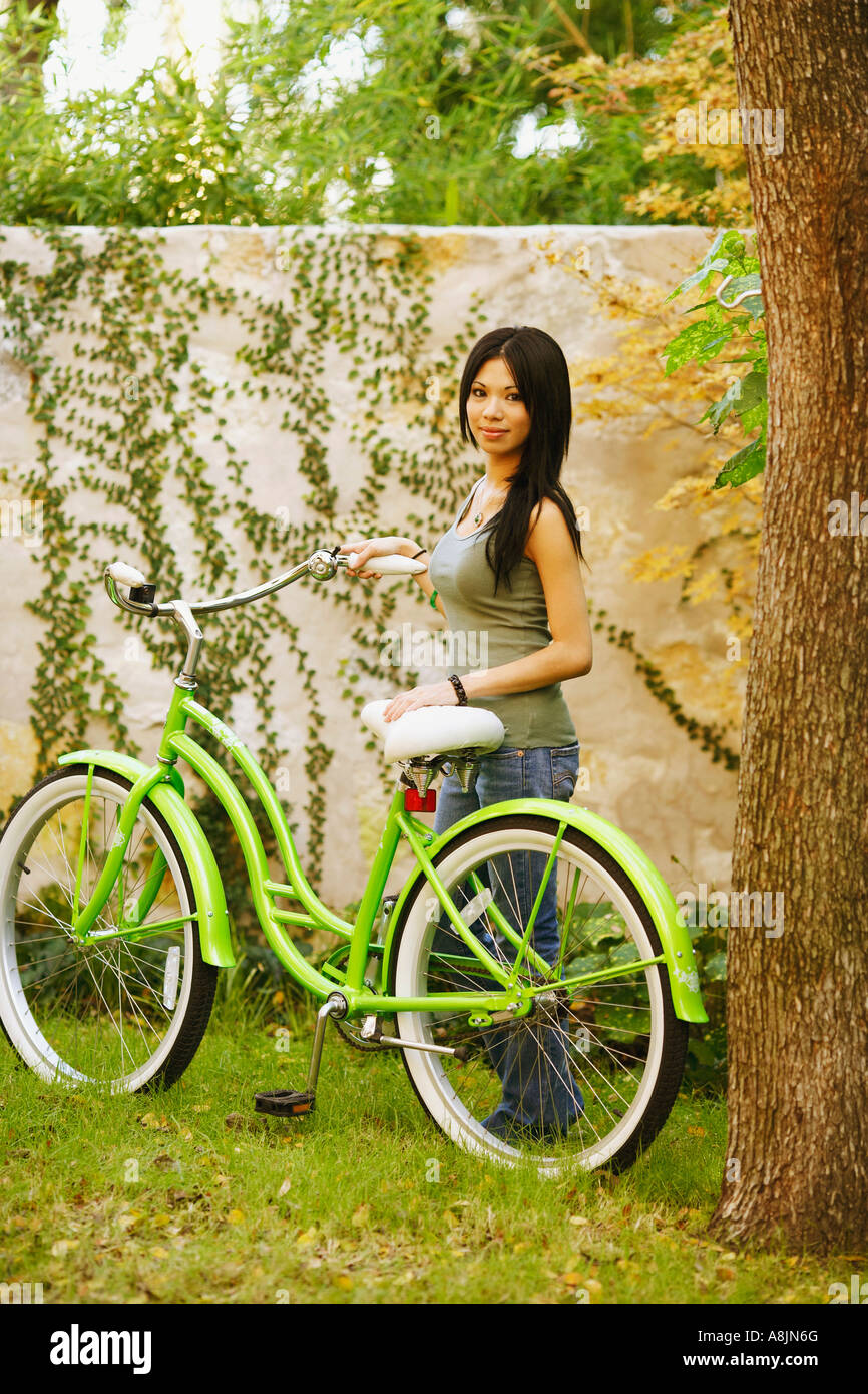 Portrait of a young woman standing with a bicycle Stock Photo